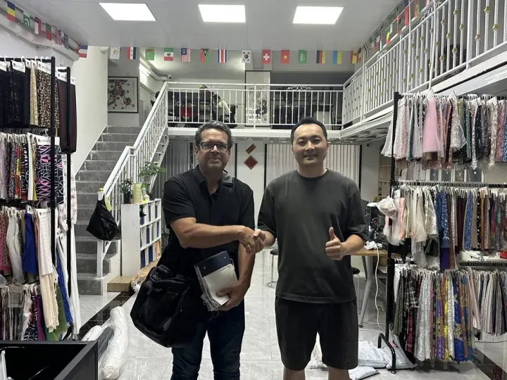 Buyer and YAQIXIN textile team confirming cooperation after showroom visit