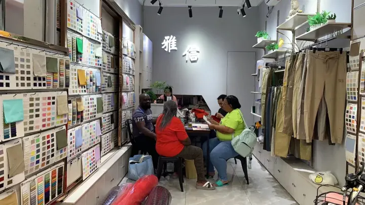Buyers comparing fabric samples in YAQIXIN showroom